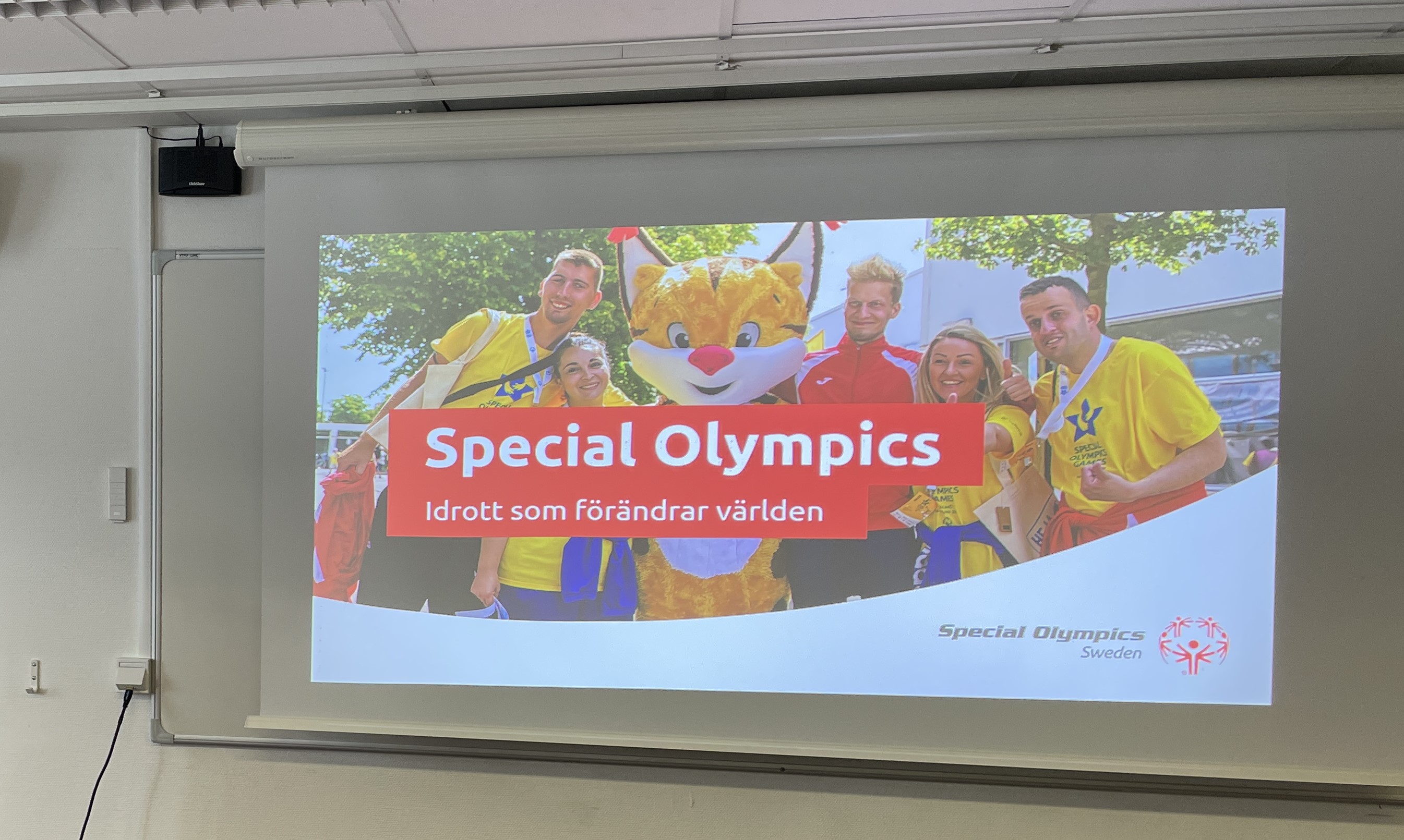 Bild på projektorduk som visar en bild med texten Special Olympics